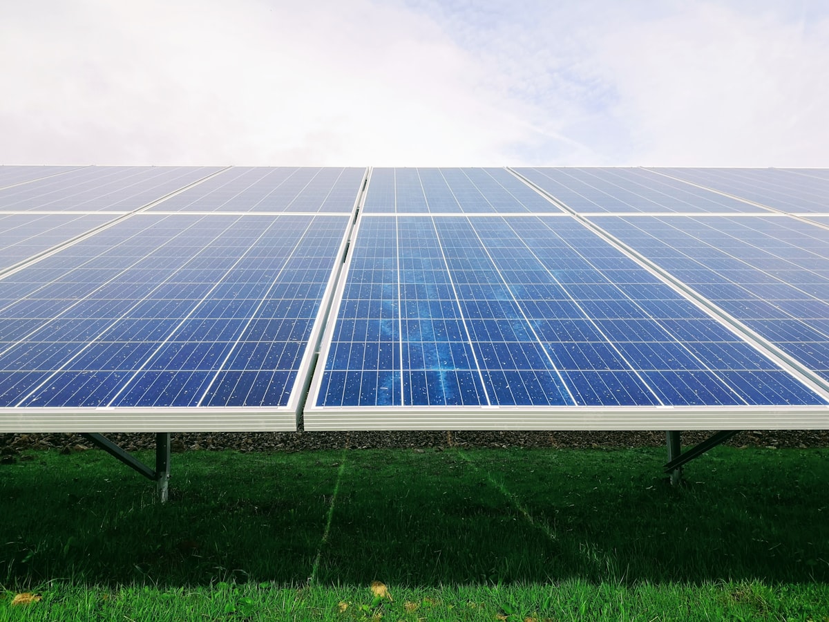 Blue photovoltaic panels at a solar plant under a sunny sky